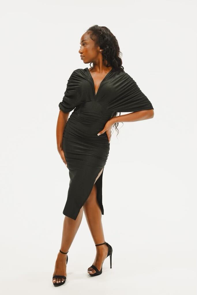 Kimaiya, a Black woman and St. Louis dancer, posing in a stylish black dress and high heels